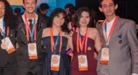 Quatro estudantes, sendo dois homens e duas mulheres em pé com medalhas no peito