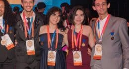 Quatro estudantes, sendo dois homens e duas mulheres em pé com medalhas no peito