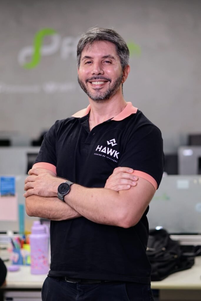 homem de braços cruzados em frente a logo da fpfetch