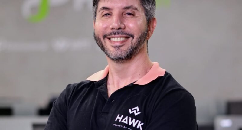 homem de braços cruzados em frente a logo da fpfetch