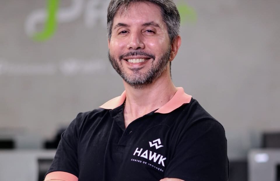 homem de braços cruzados em frente a logo da fpfetch