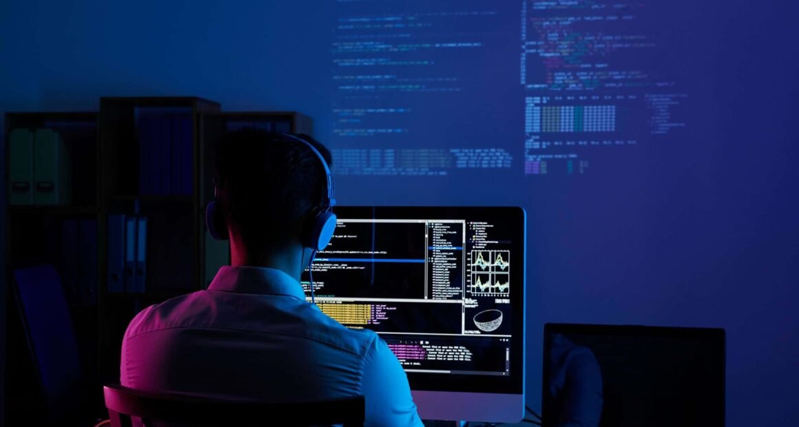 Homem de costas na frente de um computador