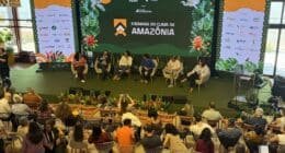 Um grupo de pessoas sentadas em um evento com pessoas no palco em belém