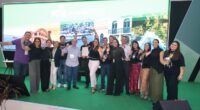 Um grupo de pessoas em cima de um palco com um telão de led ao fundo