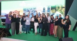 Um grupo de pessoas em cima de um palco com um telão de led ao fundo