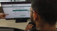 Pessoa de óculos olhando para a tela de um computador