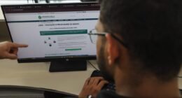 Pessoa de óculos olhando para a tela de um computador