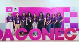 um grupo de mulheres atrás de uma placa escrita ada conecta