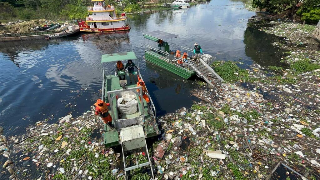 duas embarcações coletando lixo do rio negro em manaus