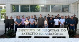 Pessoas em atrás de uma placa escrita instituto de pesquisas do exército na amazônia