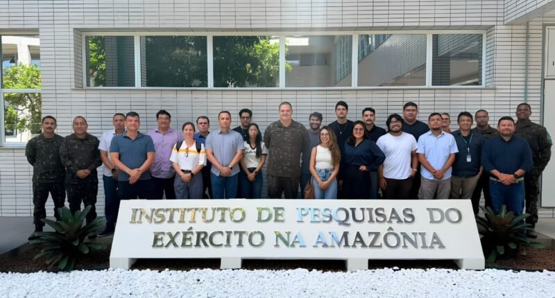 Pessoas em atrás de uma placa escrita instituto de pesquisas do exército na amazônia