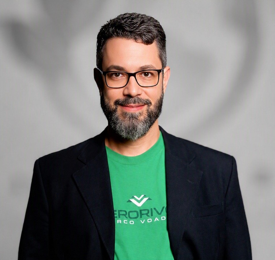 Homem de barba grisalha de camisa verde e blazer preto